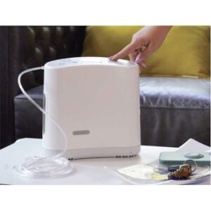 Woman's hand presses button on Oxlife Liberty Portable Oxygen Concentrator