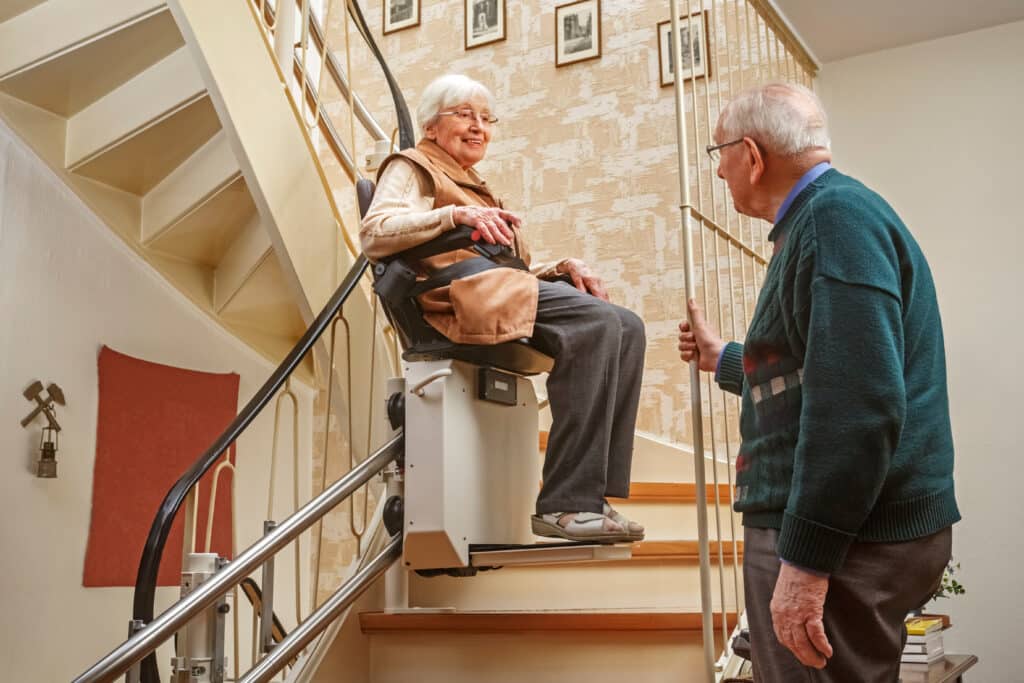 Woman uses stair lift to ascend stairs | You Can Home Medical